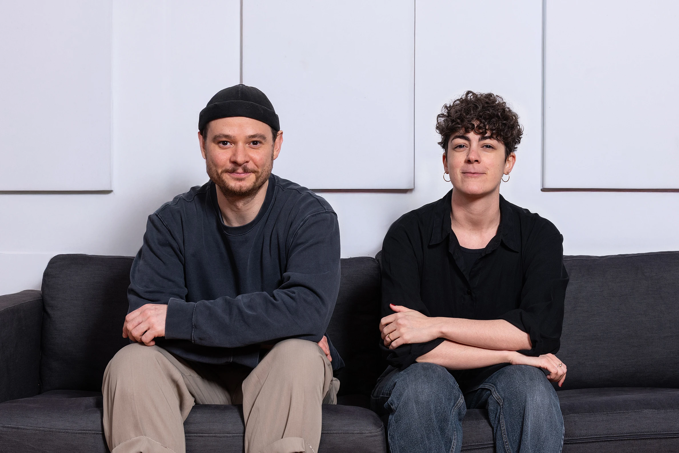 Zwei Personen des mimaps-Teams sitzen lächelnd am Tisch in einem hellen Raum